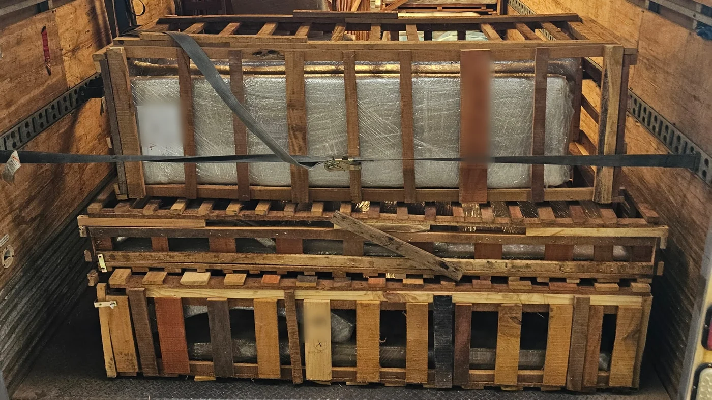 Freight built into custom wooden crates and ratchet-strapped inside a Bravo 24 truck.